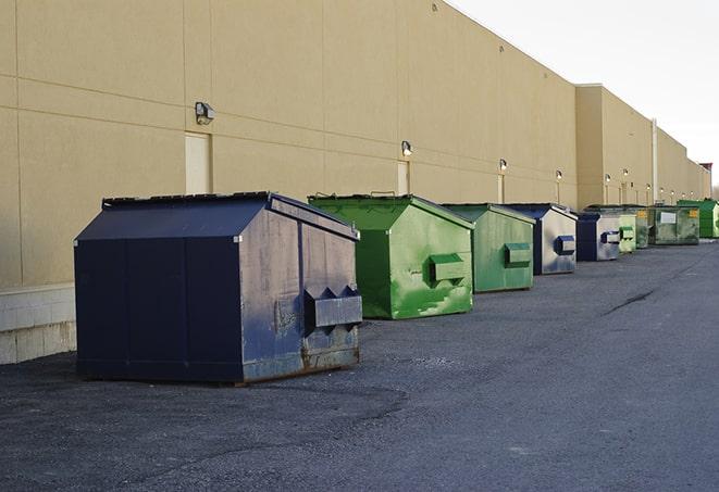 tilted front-load dumpsters being emptied by waste management workers in Duarte